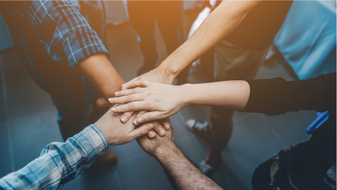 Hands placed together on top of each other in a sign of support.