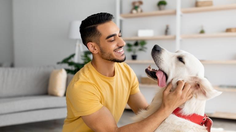 Young man hanging out with his dog in his apartment