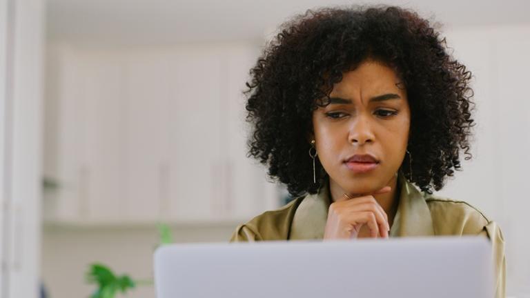 Woman looking at computer with frustrated expression