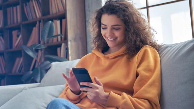 Person smiling while browsing phone.