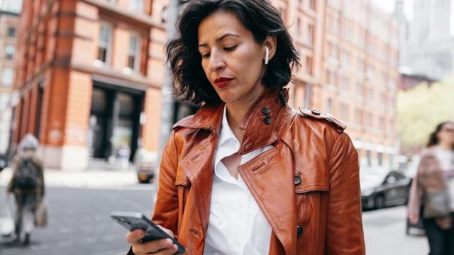 Woman listening to podcast while walking in city