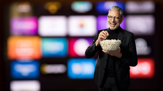 Brad Bellflower with popcorn in front of media logos