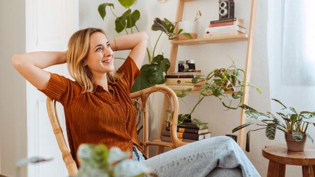 Young woman relaxes in plant-filled apartment